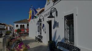 a white building with benches and flags on it at El Rompido in El Rompido
