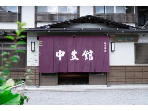 un edificio con una pancarta púrpura con escritura china. en Chuseikan - Vacation STAY 34497v, en Shima