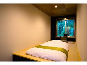 una cama en una habitación con ventana en Chuseikan - Vacation STAY 34497v, en Shima