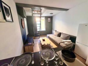 a living room with a couch and a table with wine glasses at Jolie Duplex - Grand place - Hyper centre-Netflix in Arras