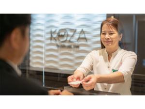a woman standing in front of a counter with a man at Hotel Koza - Vacation STAY 84847v in Okinawa City