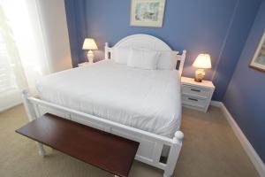 a bedroom with a white bed and blue walls at Shipwatch 405A by Wild Dunes, Oceanfront Condo in Isle of Palms