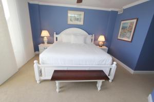 a blue bedroom with a white bed and two lamps at Shipwatch 405A by Wild Dunes, Oceanfront Condo in Isle of Palms