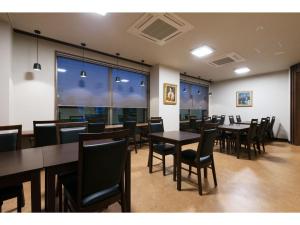 ein Esszimmer mit Tischen und Stühlen und Fenstern in der Unterkunft Credo Hotel Hakodate - Vacation STAY 87584v in Hakodate