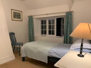 a bedroom with a bed and a window at Cute cob cottage in Winterborne Stickland
