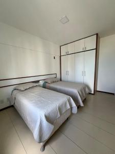 two beds in a room with white walls at Apartmento em Boa Viagem in Recife +22 photos