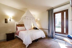 a bedroom with a white bed with a canopy at Appartamento Holly House in Radda in Chianti
