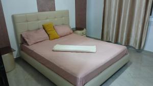 a bed with pink and yellow pillows on it at Saidia in Saïdia