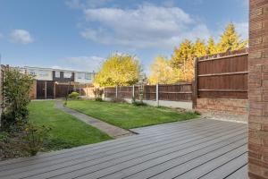 a backyard with a wooden deck and a fence at Clicketts - 3-Bedroom, Full Entire House, Sleeps 6 guests, Free wifi, Street Parking, Smart TV, Basildon, Essex London in Basildon