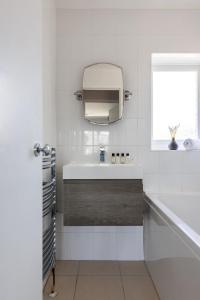 a bathroom with a sink and a tub and a television at Clicketts - 3-Bedroom, Full Entire House, Sleeps 6 guests, Free wifi, Street Parking, Smart TV, Basildon, Essex London in Basildon +51 photos
