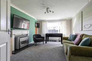 a living room with a couch and a piano at Clicketts - 3-Bedroom, Full Entire House, Sleeps 6 guests, Free wifi, Street Parking, Smart TV, Basildon, Essex London in Basildon
