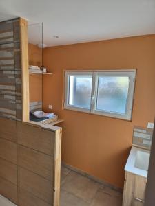 a bathroom with a sink and two windows at Jolie maison de campagne avec spa en option in Rauville-la-Place +8 photos