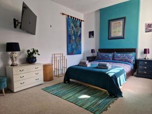 een slaapkamer met een bed en een televisie. bij West Street Views - Flat 1 in Wimborne Minster