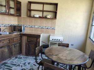 a kitchen with a table and a sink and a stove at Casa Elefante Dormido in Panajachel
