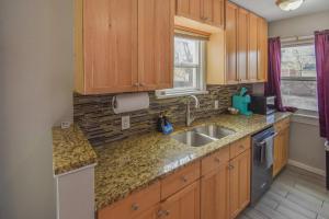 Una cocina con gabinetes de madera y un fregadero. en Cozy upper unit great for family visiting Zoo medica campus and downtown, en Denver