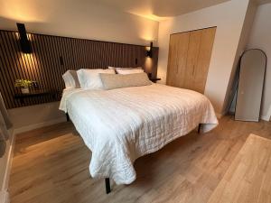 a bedroom with a large bed with white sheets and pillows at DWELL in Alaska "BIGGER" Unit m in Fairbanks