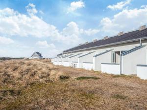 a row of white buildings on top of a field at 6 person holiday home in Brovst in Brovst