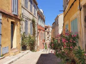 an alley in an old town with buildings and flowers at Home lysea Major in Marseille