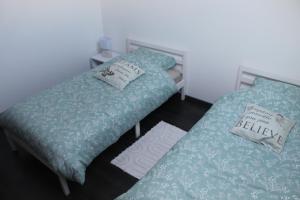 two beds sitting next to each other in a room at Le Cosy Julian in Roye