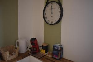 a clock hanging on a wall above a kitchen counter at Home lysea Major in Marseille