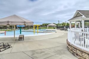 a pool with a playground with chairs and umbrellas at 5 Mi to Bethany Beach Townhome with Pool! in Millville
