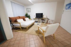 Una sala de estar con un sofá y un televisor. en Campbells Cove Unit 12, en Caloundra