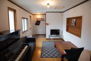 a living room with a couch and a piano at Powder Temple in Hakuba