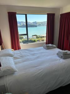 Diamond HarbourにあるCharteris Bay Holiday Houseの大きなベッドと大きな窓のある寝室