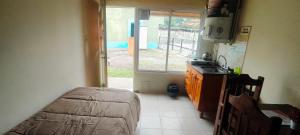 a kitchen with a bed and a sink and a window at Terralta Mini Cabañas y Camping in Las Compuertas