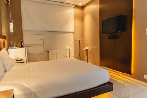 a bedroom with a white bed and a flat screen tv at Luna Blu Studio in Campo Magro