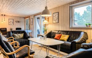 a living room with leather furniture and a table at Amazing Home In Ringkøbing With Kitchen in Søndervig