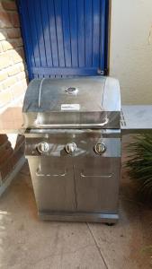 a grill sitting on a sidewalk next to a blue door at Toro 1, Oro y Azul in Cabo San Lucas