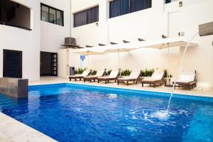 a swimming pool with a fountain in a building at Aspira Hotel Playa del Carmen in Playa del Carmen