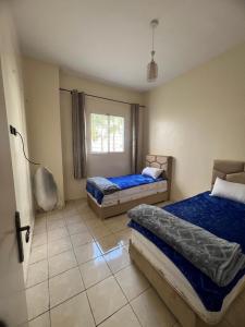 Oulad Yakoubにあるappartement nouveau sala al jadidaのベッド2台と窓のある寝室