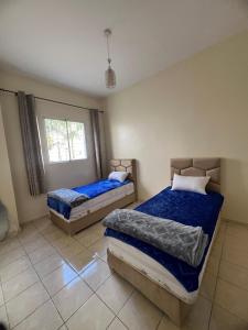 Oulad Yakoubにあるappartement nouveau sala al jadidaのベッド2台と窓のある寝室 +6枚の写真
