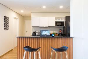 una cucina con bancone e 2 sgabelli blu di Hestia at Asuncion Cozy Bright & Smart 2BDR ad Asunción