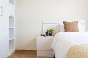una camera con un letto bianco e un comò bianco di Hestia at Asuncion Cozy Bright & Smart 2BDR ad Asunción