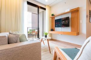 un soggiorno con un divano e una TV di Hestia at Asuncion Cozy Bright & Smart 2BDR ad Asunción