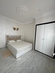 a white bedroom with a bed and a large cabinet at Mini Villa alhoceima in El Arba de Trougout +22 photos