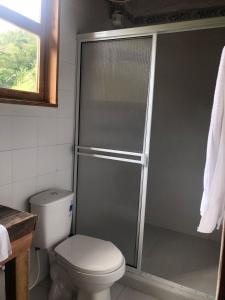 a bathroom with a toilet and a glass shower at Cabañas rurales Arabi in Pereira