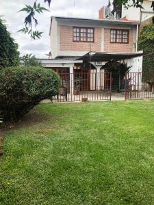a house with a fence in front of a yard at Casa de los Ángeles in San Salvador de Jujuy