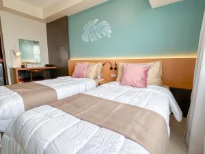 two beds sitting next to each other in a room at Cozy Space by Nomad Space PH at Horizons 101 Cebu City with Pool, Netflix, Wifi in Cebu City