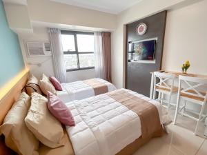 a hotel room with two beds and a window at Cozy Space by Nomad Space PH at Horizons 101 Cebu City with Pool, Netflix, Wifi in Cebu City +38 photos