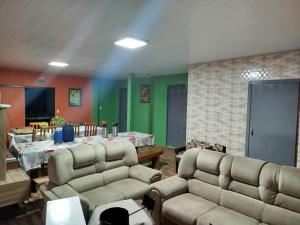 a living room with two couches and a table at Pousada Bella Montanha in Louro Müller
