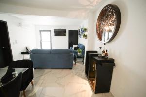 sala de estar con sofá azul y espejo en Casa Carolina Remodeled Home, en Guadalajara