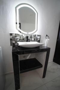 Un baño con un lavabo con un espejo grande. en Casa Carolina Remodeled Home, en Guadalajara 20 fotos más