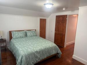 a bedroom with a bed with a green comforter at Cape Cod Hyannis Rendezvous' in Barnstable