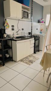 Una cocina con gabinetes blancos y un microondas. en Sun-Whay, en Ubatuba 14 fotos más