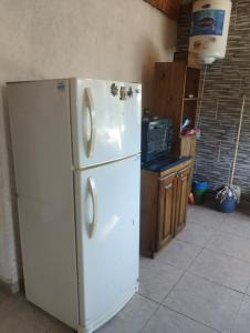 a white refrigerator freezer sitting in a kitchen at Casa doña tati in Cortaderas