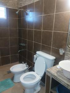 a bathroom with a toilet and a sink at Casa doña tati in Cortaderas +12 photos
